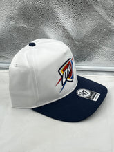 Load image into Gallery viewer, Oklahoma City Thunder NBA '47 Brand White Two Tone Hitch Adjustable Snapback Hat set against a sports-themed backdrop, perfect for showcasing team spirit.