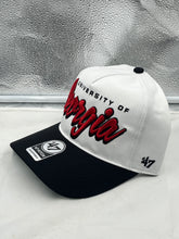 Load image into Gallery viewer, Georgia Bulldogs NCAA '47 Brand White TT Script Hitch Adjustable Snapback Hat displayed against a wooden background, showcasing its adjustable fit and iconic logo.