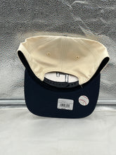 Load image into Gallery viewer, Man wearing Cleveland Guardians MLB '47 Brand Natural TT Hitch Adjustable Snapback Hat at an outdoor game, proudly showing team spirit and style.