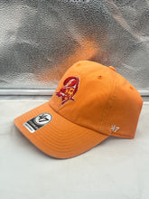 Load image into Gallery viewer, Tampa Bay Buccaneers NFL '47 Brand Throwback Orange Clean Up Adjustable Hat displayed on a wooden surface showcasing its vibrant orange color and iconic Buccaneers logo.