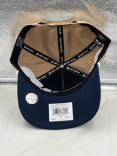 Load image into Gallery viewer, Man wearing Braves Vs Guardians 1995 World Series Dueling MLB '47 Khaki Hitch Adjustable Hat at a baseball game.