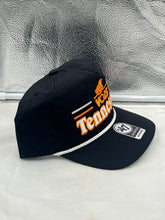 Load image into Gallery viewer, Model wearing the Tennessee Volunteers NCAA '47 Throwback Black Hitch Snapback Adjustable Hat at an outdoor event, illustrating its comfortable fit and team spirit.
