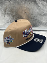 Load image into Gallery viewer, Yankees Vs Padres 1998 World Series Dueling MLB '47 Khaki Hitch Adjustable Hat displayed on a wooden surface highlighting its classic khaki color.