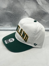 Load image into Gallery viewer, Close-up view of the Oakland Athletics MLB '47 Brand White TT Script Hitch Adjustable Snapback Hat featuring the stylish TT Script logo.
