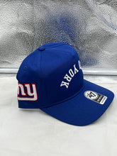 Load image into Gallery viewer, Person wearing the New York Giants NFL '47 Brand Blue Reversed Script Hitch Snapback Adjustable Hat, demonstrating a casual game-day style.