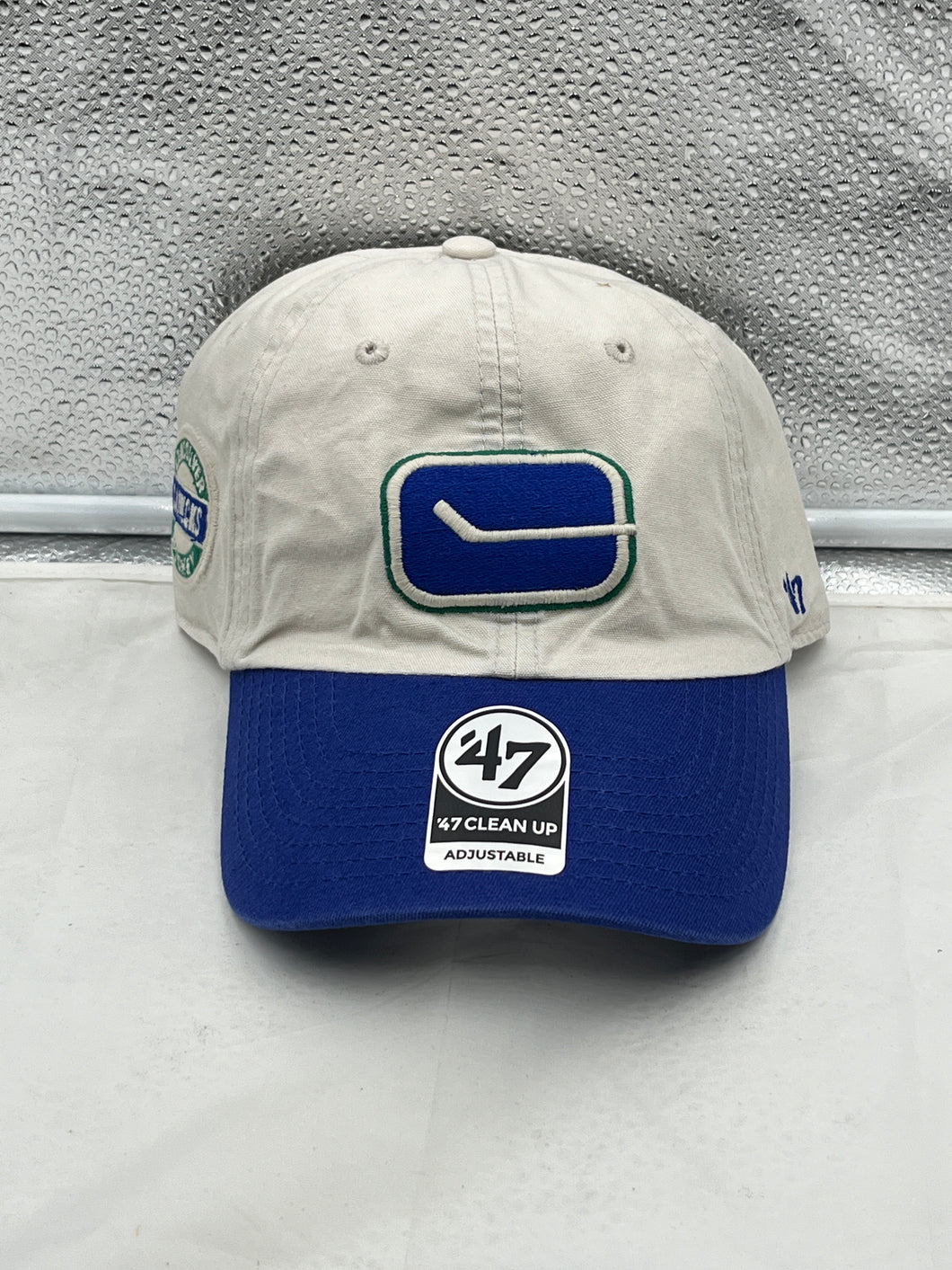 Vancouver Canucks NHL '47 Brand Throwback Clean Up Tan Two Tone Adjustable Hat displayed front view, showcasing its vintage logo and two-tone design.