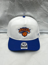 Load image into Gallery viewer, New York Knicks NBA &#39;47 Brand White Two Tone Hitch Adjustable Snapback Hat displayed on a wooden table with a blurred basketball background.
