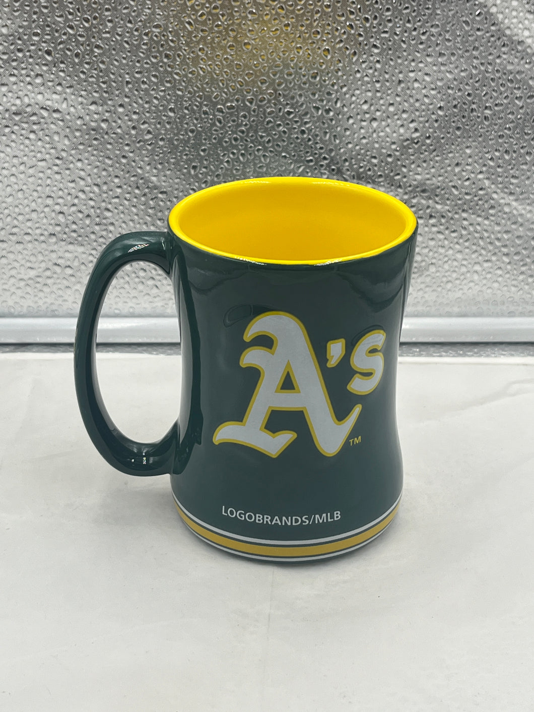 a green and yellow coffee mug sitting on top of a counter