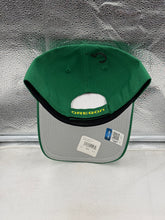 Load image into Gallery viewer, Model wearing the Oregon Ducks NCAA '47 Brand Green MVP Adjustable Strapback Hat during game day, highlighting its versatility and style.
