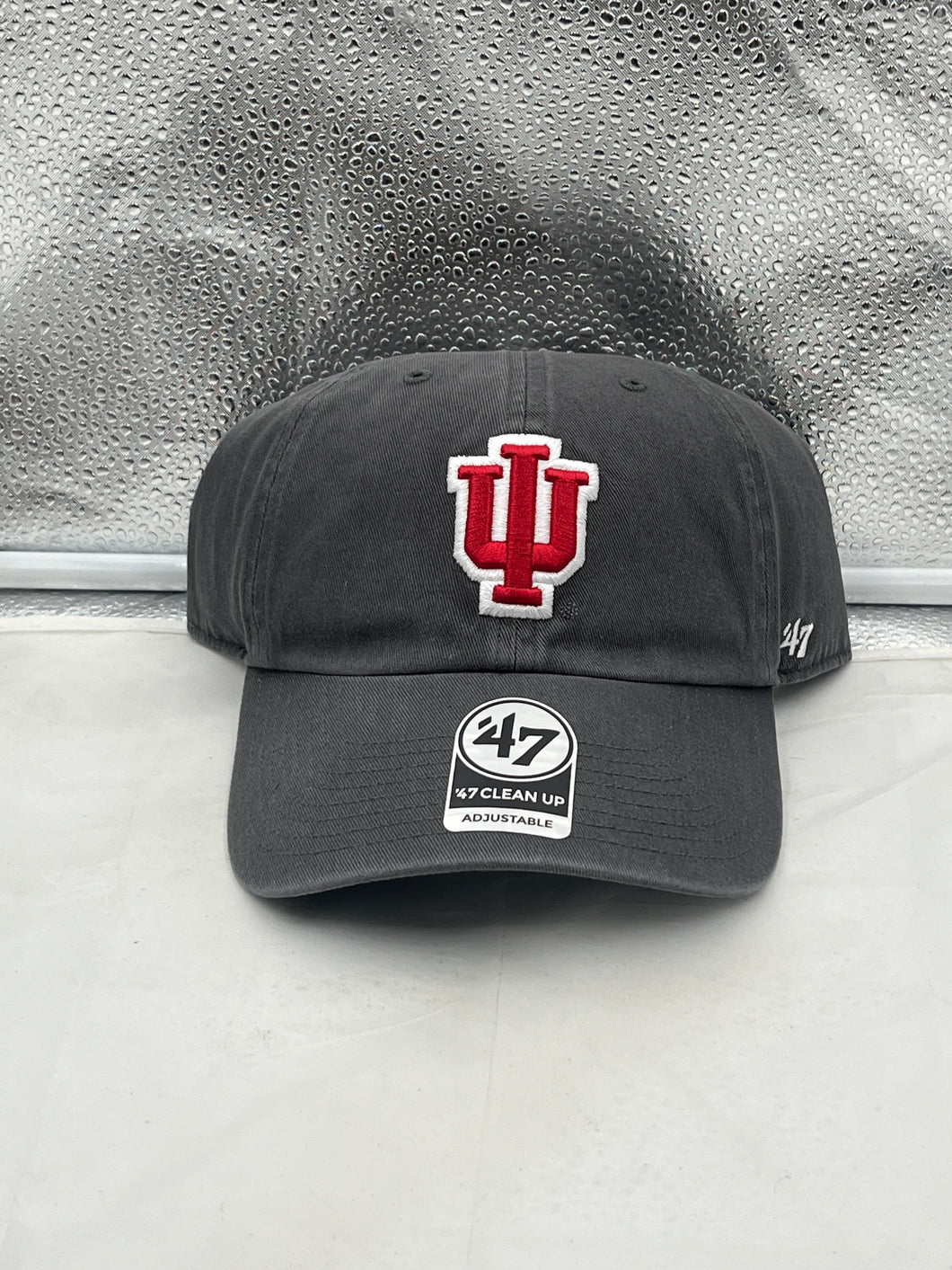 Indiana Hoosiers NCAA '47 Brand Gray Clean Up Adjustable Hat displayed on a wooden table, showcasing its relaxed fit and iconic team logo.