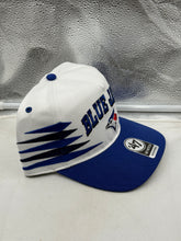 Load image into Gallery viewer, Stylish model wearing the Toronto Blue Jays MLB '47 Brand White TT Diamond Hitch Adjustable Snapback Hat at a sunny event.
