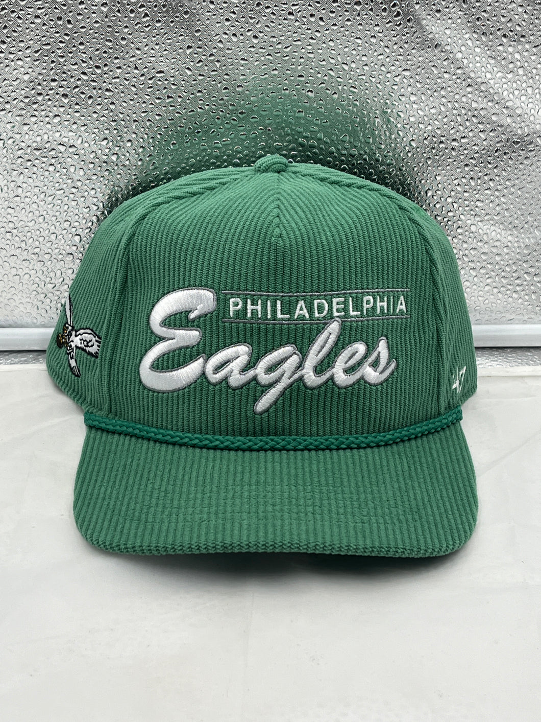 a green philadelphia eagles hat sitting on top of a counter