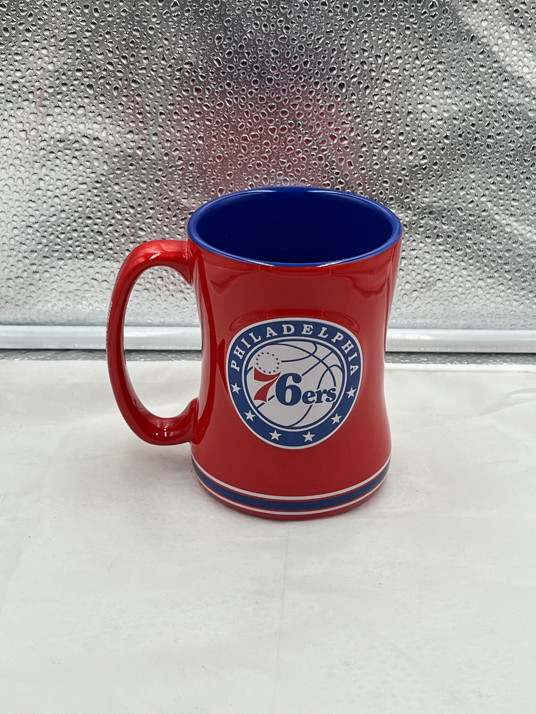 a red and blue mug sitting on top of a counter