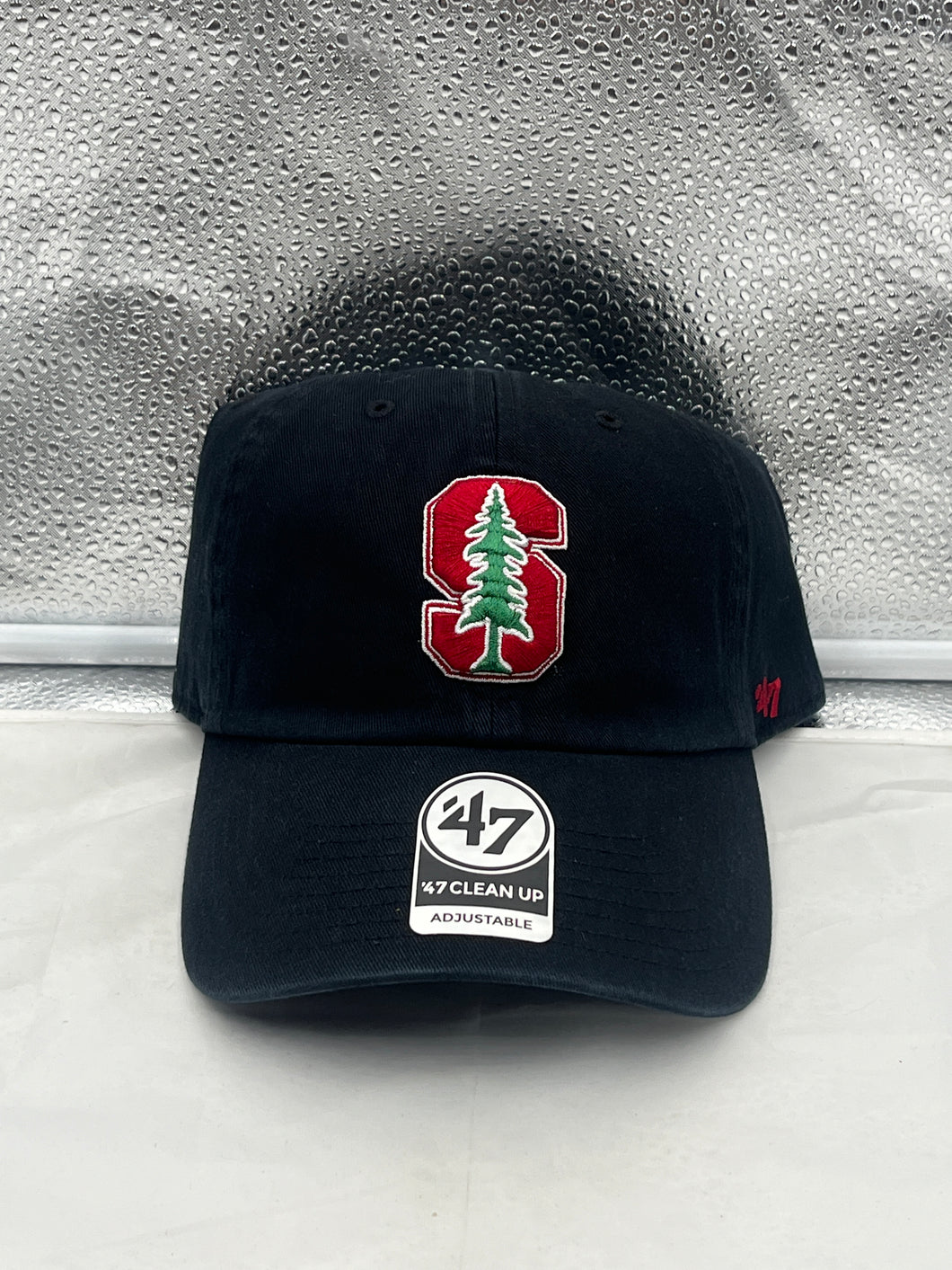 Stanford Cardinal NCAA '47 Brand Black Clean Up Adjustable Strapback Hat displayed on a table, showcasing its logo and adjustable strap design.