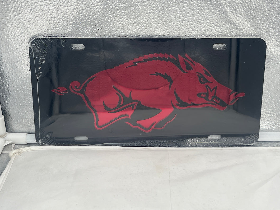 Arkansas Razorbacks NCAA Black Mirrored Laser Cut License Plate by Craftique showcasing a sleek mirrored finish and intricate laser-cut design featuring the iconic Razorbacks logo, ideal for demonstrating team pride on vehicles or as home decor.