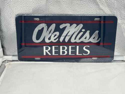 Ole Miss Rebels NCAA Blue Mirrored Laser Cut License Plate by Craftique showcasing a stylish blue mirrored finish and laser cut lettering, perfect for displaying team spirit on vehicles or home decor.