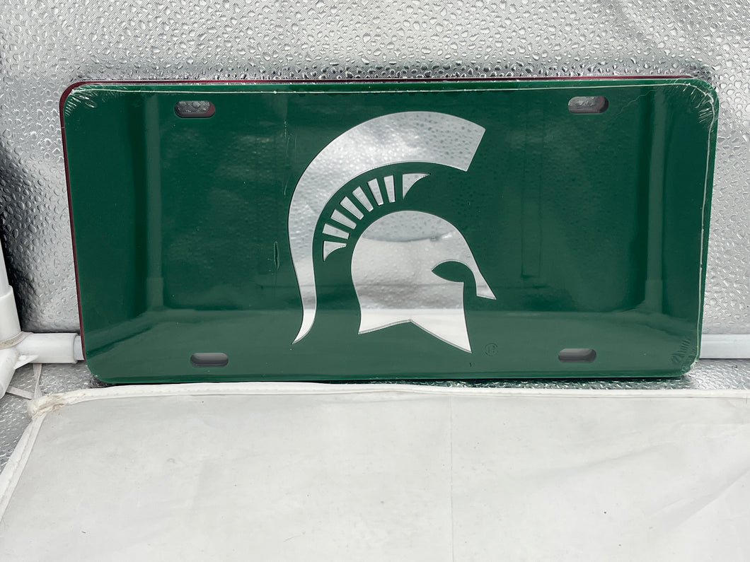 Michigan State Spartans NCAA Green Mirrored Laser Cut License Plate from Craftique showcasing vibrant green color and elegant laser-cut design, perfect for vehicle decoration and team pride.