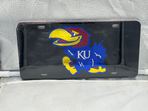 Kansas Jayhawks NCAA Black Mirrored Laser Cut License Plate from Craftique showcasing the team's logo with a sleek black finish and vibrant laser-cut details, perfect for fans to display school spirit on their vehicles.