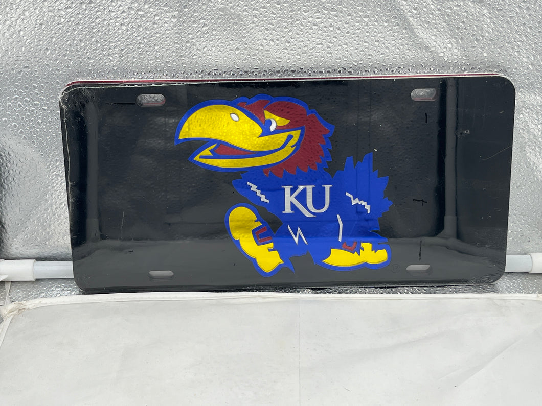 Kansas Jayhawks NCAA Black Mirrored Laser Cut License Plate from Craftique showcasing the team's logo with a sleek black finish and vibrant laser-cut details, perfect for fans to display school spirit on their vehicles.