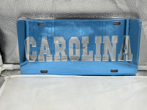 North Carolina Tar Heels NCAA Blue Mirrored Laser Cut License Plate from Craftique, showcasing the iconic Tar Heels logo with a striking mirrored finish, perfect for fans.