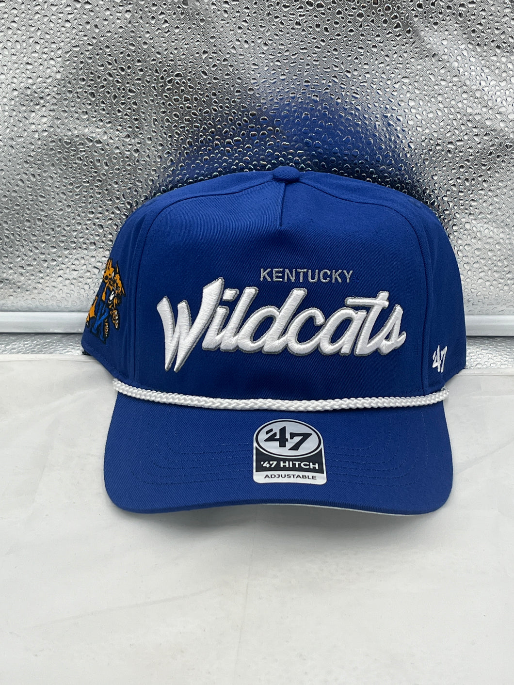 Kentucky Wildcats NCAA '47 Blue Script Rope Hitch Adjustable Snapback Hat displayed on a wooden surface, showcasing its vibrant blue color and stylish rope design.
