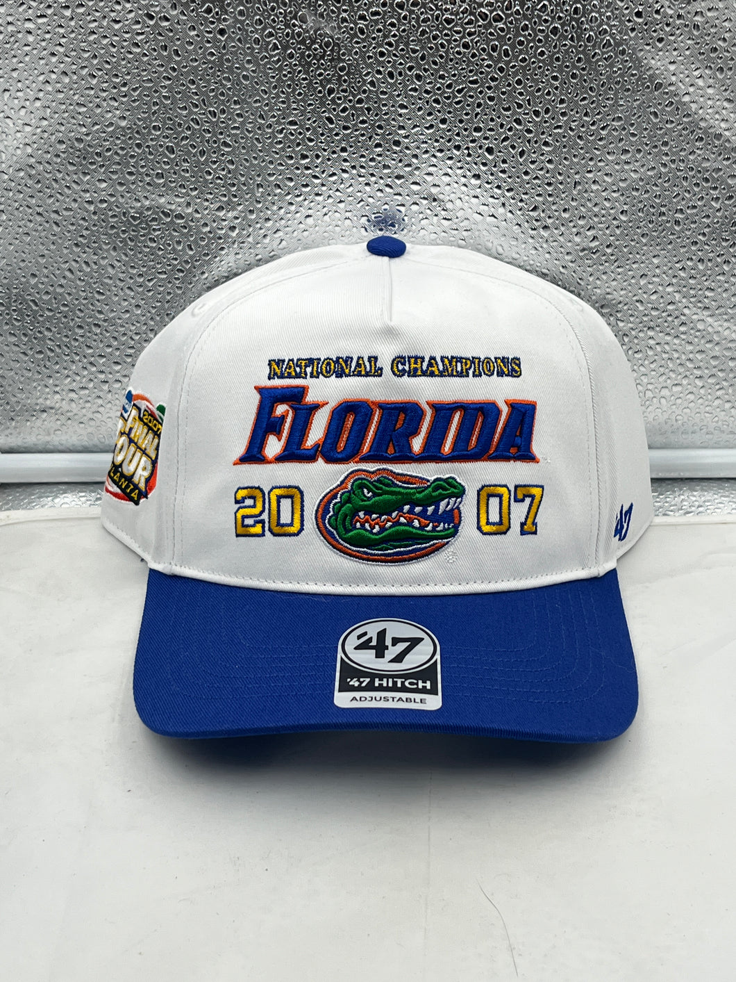 Florida Gators NCAA '47 Brand Champs White Hitch Adjustable Snapback Hat displayed on a wooden table.